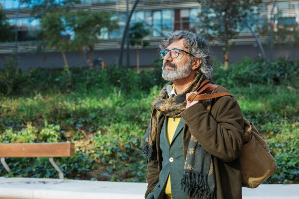 istock Professional middle-aged businessman looking away while standing outdoors at the financial district 1385678564