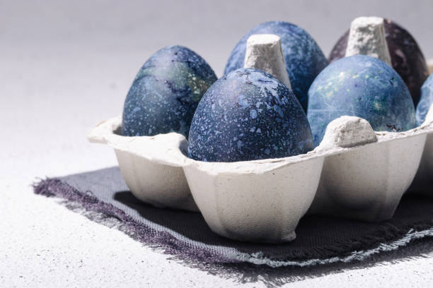 istock Blue easter eggs dyed with hibiscus tea in an egg carton on a white concrete background 1385678971