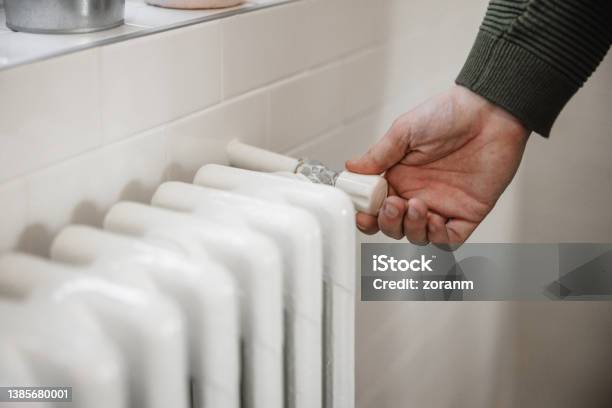 Trying To Turn The Heat Up On Home Radiator Heater New World Economic Crisis Stock Photo - Download Image Now