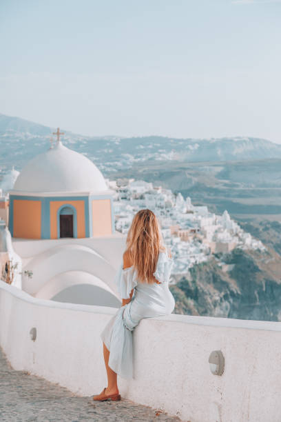 a una joven le gusta viajar y mirar la vista en santorini, grecia - santorini greece church travel fotografías e imágenes de stock