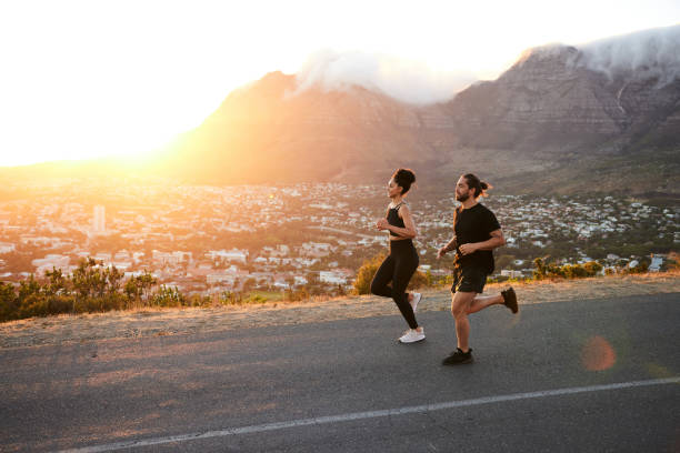 istock Fit young couple running together on a hill at sunset 1385688459