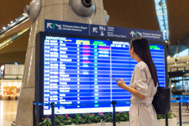 여행을 시작하자, 비행 시간표 보드를 찾고 여자. - travel insurance 뉴스 사진 이미지