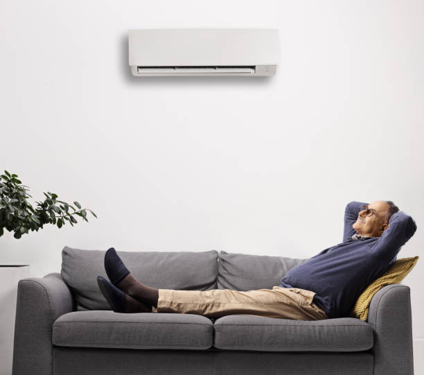 istock Mature man resting on a sofa under an air conditioning unit 1385689619