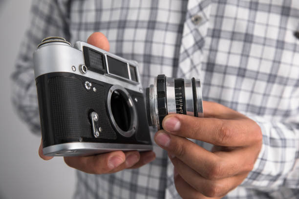 istock man holding vintage camera with lens 1385690010