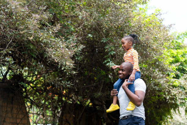 istock Little girl exploring nature sitting on fathers shoulders 1385693413