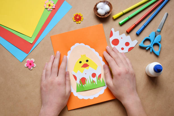 istock Making of handmade Easter decoration. Child made greeting card in egg shape. Childrens DIY concept, gift with your own hands. Hobby, paper crafts at home or  in kindergarten. 1385694020