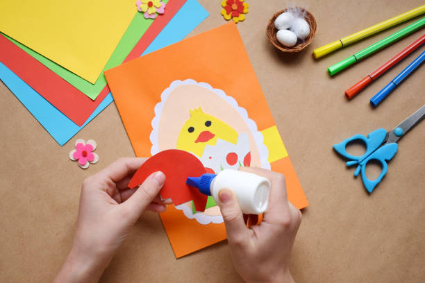 istock Making of handmade Easter decoration. Child made greeting card in egg shape. Childrens DIY concept, gift with your own hands. Hobby, paper crafts at home or  in kindergarten. 1385694041