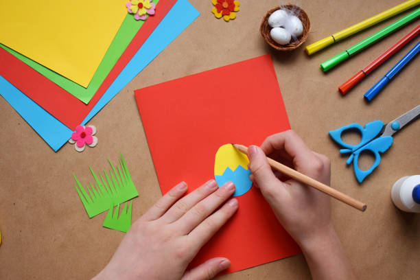 istock Making of handmade Easter decoration. Child made greeting card in egg shape. Childrens DIY concept, gift with your own hands. Hobby, paper crafts at home or  in kindergarten. 1385694042