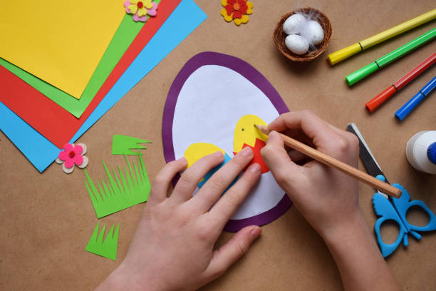 istock Making of handmade Easter decoration. Child made greeting card in egg shape. Childrens DIY concept, gift with your own hands. Hobby, paper crafts at home or  in kindergarten. 1385694046