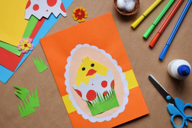 istock Making of handmade Easter decoration. Child made greeting card in egg shape. Childrens DIY concept, gift with your own hands. Hobby, paper crafts at home or  in kindergarten. 1385694054