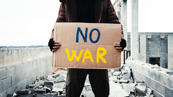 Ukrainian boy holding an anti-war placard in his hand