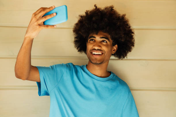 istock African american man with african hairstyle using phone 1385698386