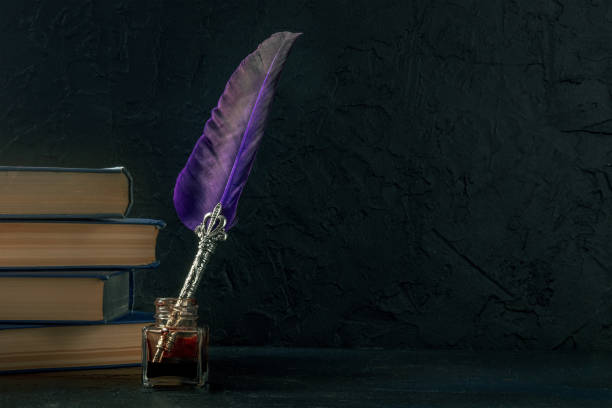 istock Quill pen with a retro ink well and a stack of old books, a side view 1385698698