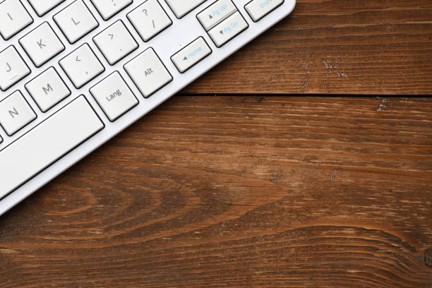 Laptop keyboard on a wooden background with copy space. Close up.