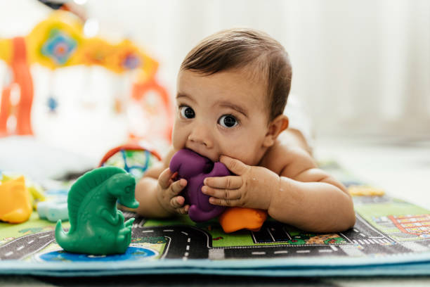 床におもちゃで遊ぶ赤ちゃん。 - baby beautiful caucasian one person ストックフォトと画像