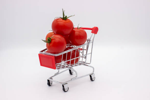 Tomatoes in metal basket on white background. Isolated image