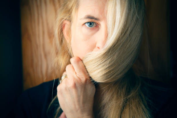 A girl with wildly static hair looks at herself in the mirror.