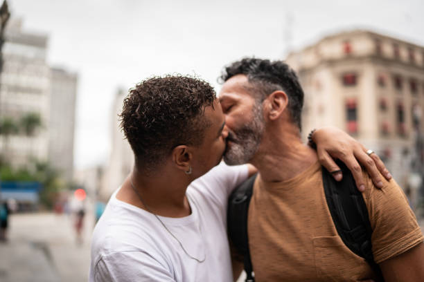 pareja gay besándose en la calle - gay man homosexual men kissing fotografías e imágenes de stock