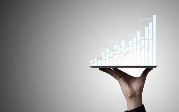 Photo of Trader holding Tablet and touching to technical graph chart  for analysis stock market data and speculator investment concept.