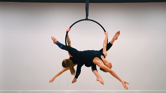 Two aerial acrobats on aerial hoop, series of photos