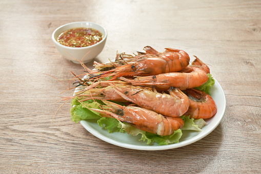 grilled river shrimp arranging with fresh lettuce on plate dipping spicy sauce