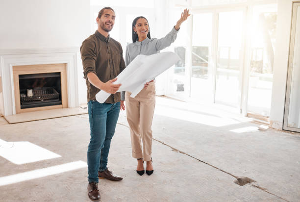 shot of two young architects looking at building plans on site - home improvement imagens e fotografias de stock