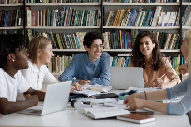 istock Happy group of diverse multiracial students studying at library. 1385706041