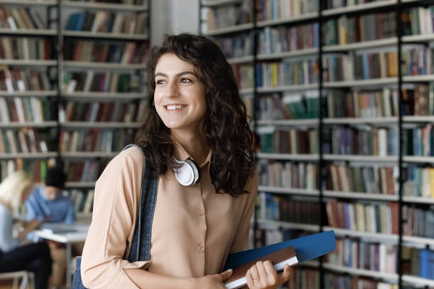 istock Happy dreamy Hispanic female student looking in distance. 1385706098