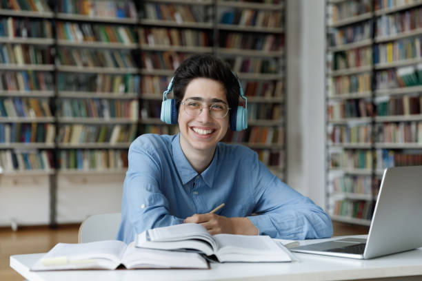 lächelnd motivierte tausendjährige jüdische männliche studenten, die in der bibliothek studierten. - male education college student nerd stock-fotos und bilder