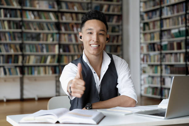 istock Happy young male Korean student recommending online courses. 1385706133
