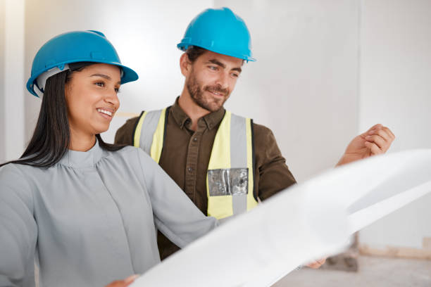 istock Shot of two young architects looking at building plans on site 1385706274