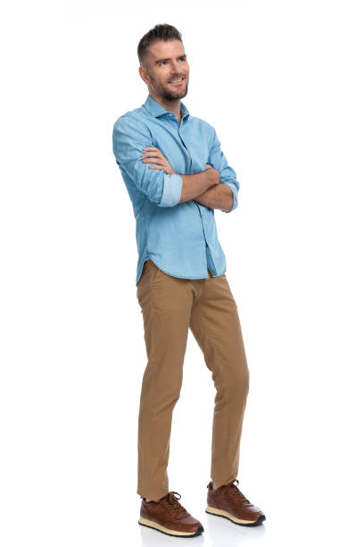 istock pensive young guy looking up and dreaming with arms crossed 1385707989