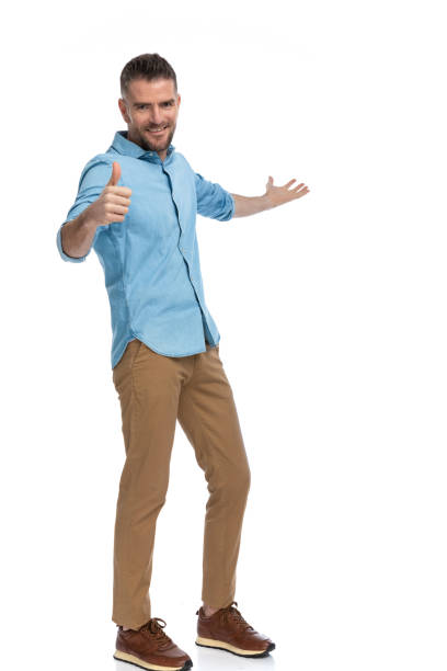 istock happy man making thumbs up gesture and presenting to side 1385708037