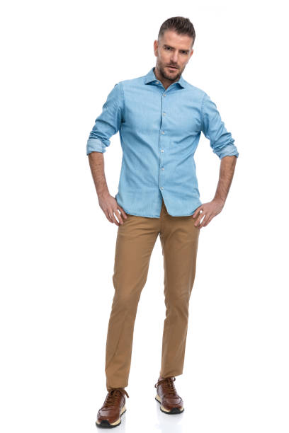 istock grizzled bearded man in blue denim shirt holding hands on hips 1385708468