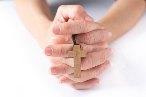 istock Woman praying with Rosary catholic cross 1385708690