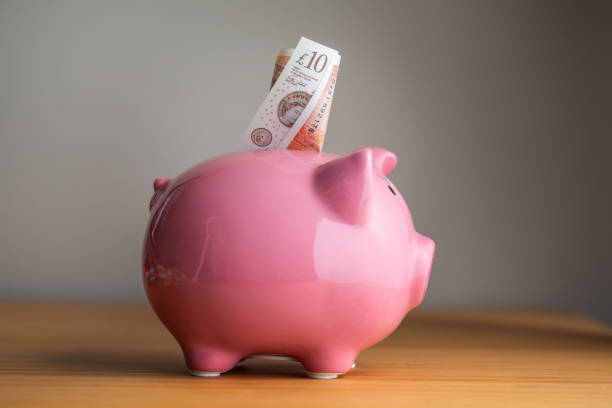Piggy Bank and Pound Piggy Bank and Pound british currency stock pictures, royalty-free photos & images
