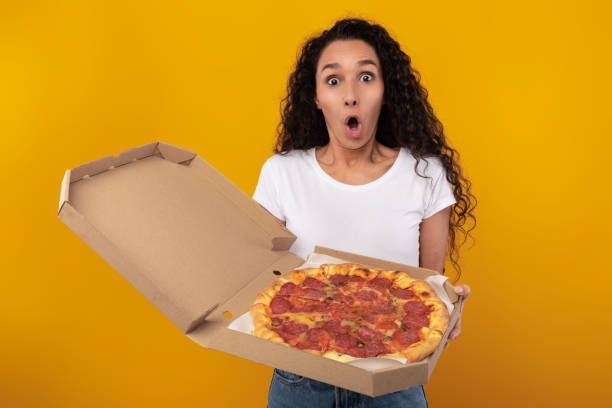 istock Shocked Woman Holding Box With Pizza At Studio 1385711728