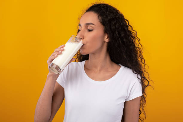 istock Young Woman Drinking Milk From Glass At Studio 1385712762