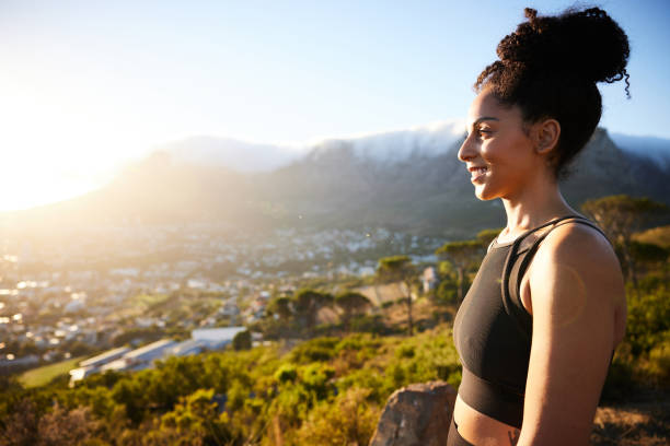 istock Smiling woman looking at the scenic view during a break from a run 1385715529