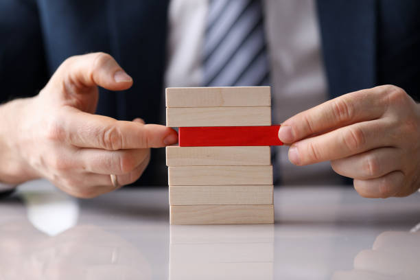 istock Man plays board game building from wooden blocks 1385715924