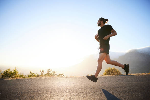 istock Fit young man out for run on a sunny afternoon in summer 1385716103