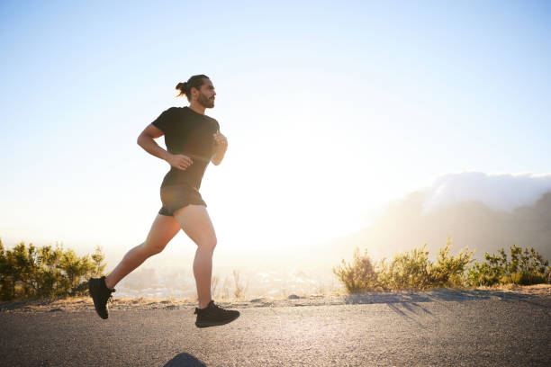 istock Fit young man running along a hill overlooking a city in summer 1385716210