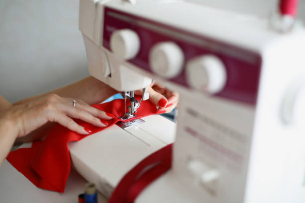 istock Woman seamstress sews a seam on a sewing machine 1385716908