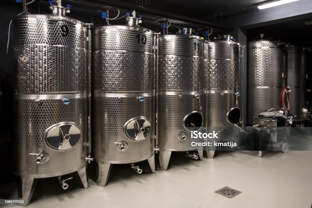 Row of Stainless Wine Tanks in Wine Cellar Row of Stainless Wine Tanks in Wine Cellar. Fermenting Stock Photo
