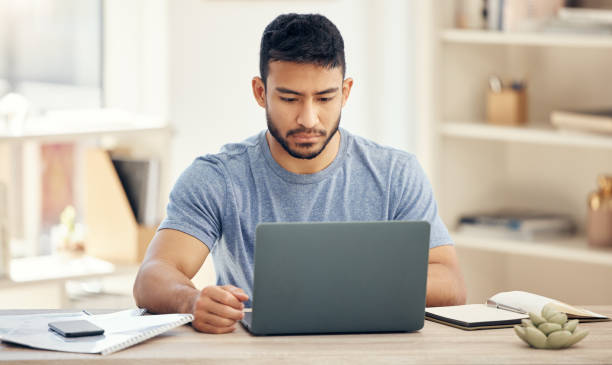 istock Shot of a young businessman using a laptop in an office at work 1385719254