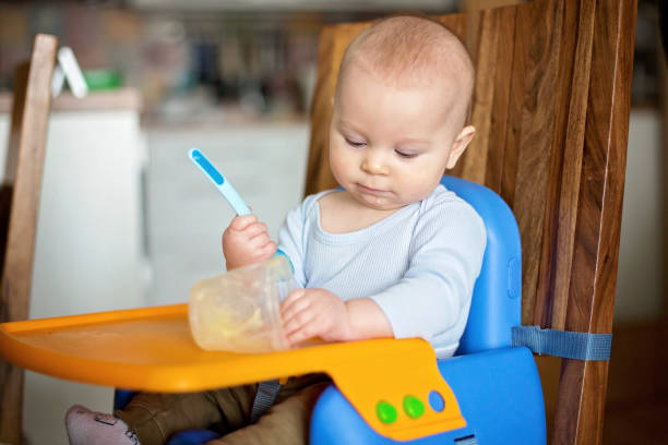 istock Little baby boy, eating mashed food for the first time 1385719602