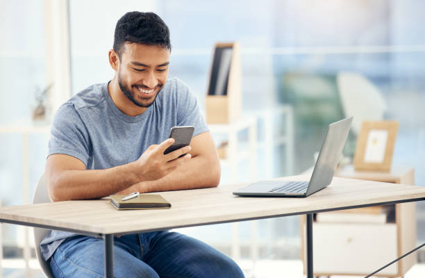 istock Shot of a young businessman using a phone in an office at work 1385720677