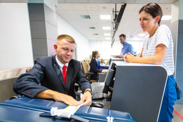 istock Airline chech-in attendant attaching tag on luggage 1385721339