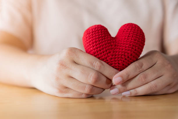 istock Adult hands holding a yarn red heart 1385721902