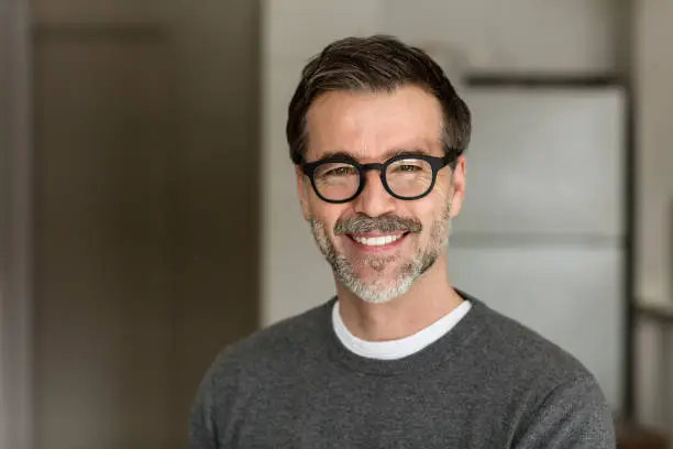 Senior Man Smiling At The Camera. In the kitchen